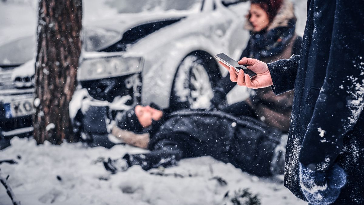 covek koji poziva hitnu pomoc, saobracajna nezgoda u pozadini